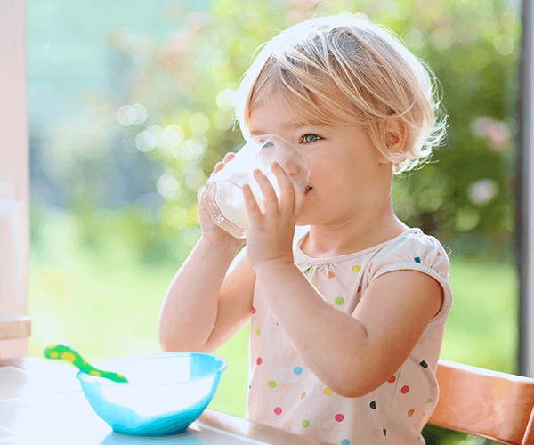 happy toddler drinking milk and eating food