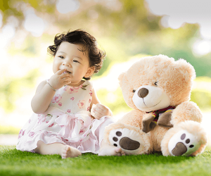 little girl sitting with a stuffed bear